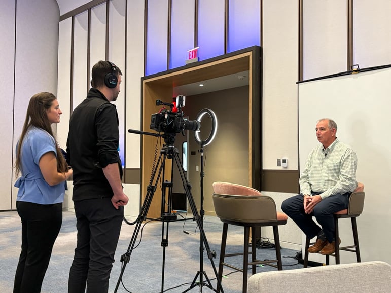 Funeral service professional seated for an on-camera interview during the Tribute Technology event in Longboat Key.