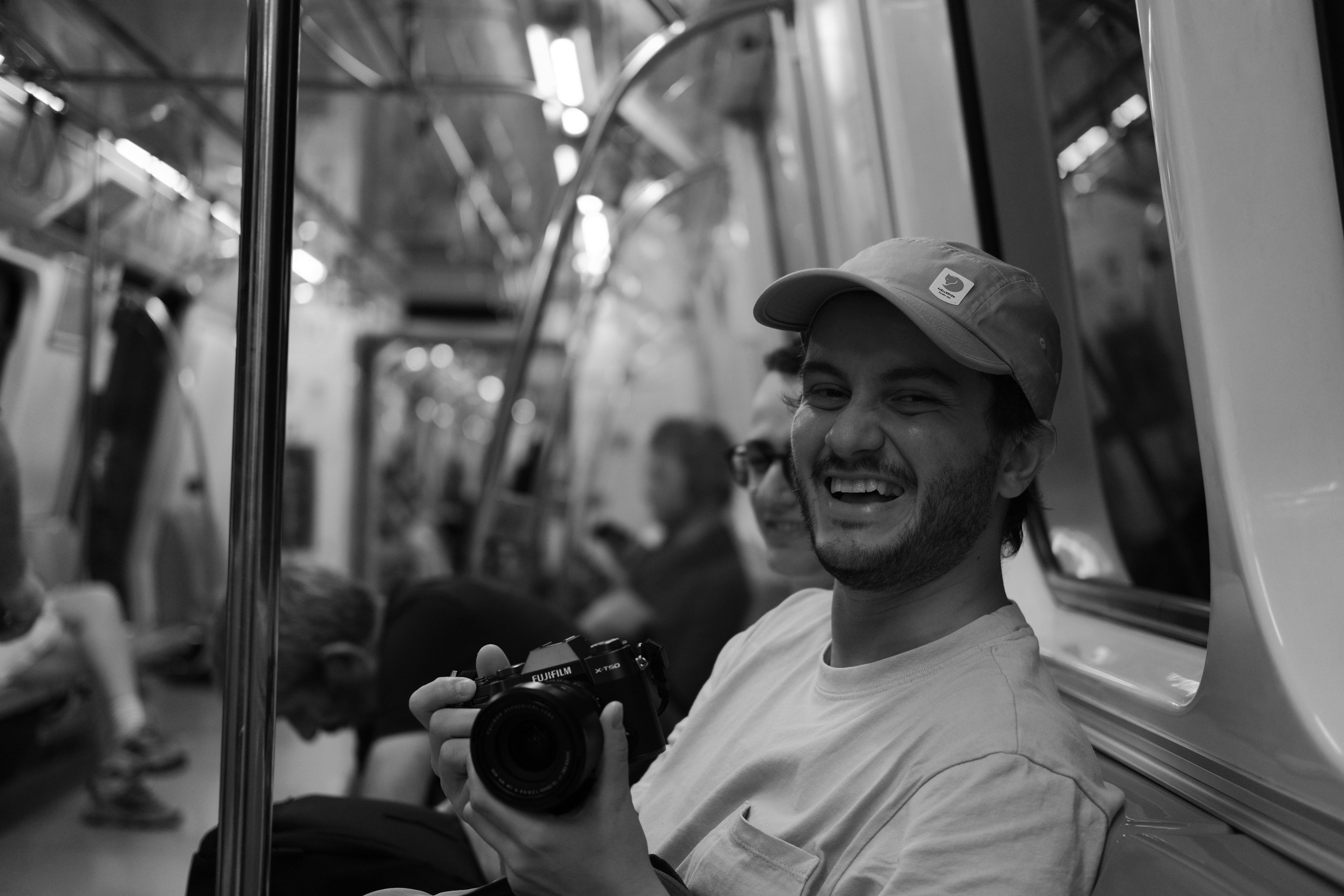 a young man laughing holding a camera