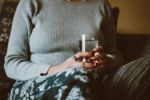grieving woman with a glass of water